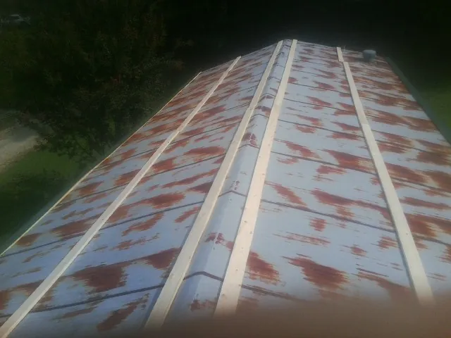 Rusted metal roof panels with new wood purlins before replacement — Storm Damage Roof Repair in Spring City by Roofing Brothers