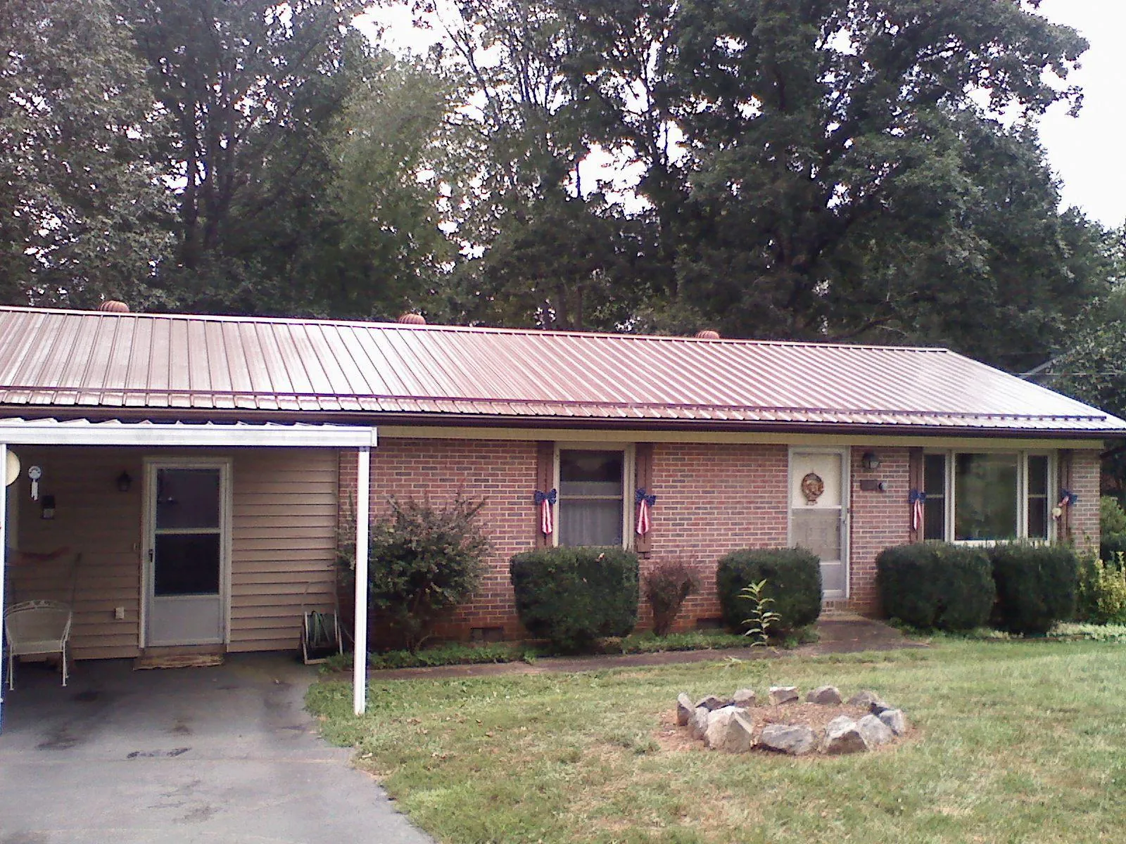 Bronze metal roof and carport on a brick ranch home — Roof Repair work by our crew in Spring City